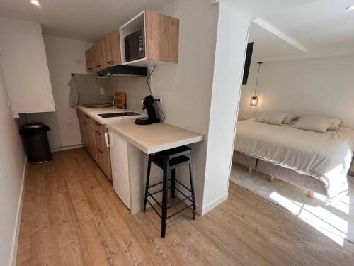 a kitchen with a desk and a bed in a room at Studio Cosy centre historique in Caen
