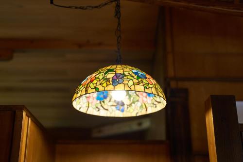 a stained glass light fixture hanging from a ceiling at Nasu YUU - 那須 悠- in Nasu-yumoto