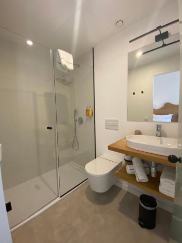uma casa de banho com um chuveiro, um WC e um lavatório. em Hotel Maïa em Ciutadella