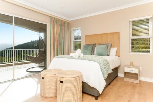 - une chambre avec un grand lit et un balcon dans l'établissement Coney Glen Penthouse, à Knysna