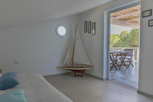 una camera da letto con una barca a vela sul muro accanto a un patio di Villa B. Calaliberotto a Cala Liberotto