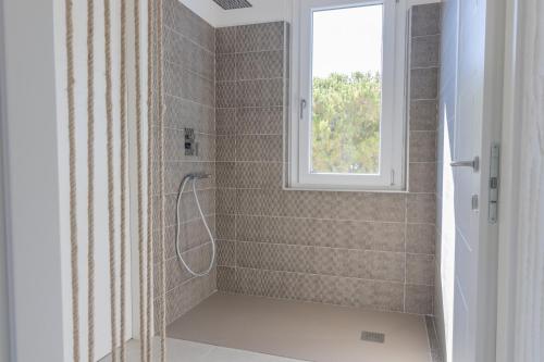 bagno con doccia e finestra di Villa B. Calaliberotto a Cala Liberotto