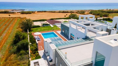 an aerial view of a white house with a swimming pool at Seafront Villa Cecelia by Ruidoso Luxury in Ayia Napa