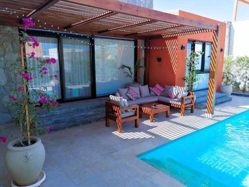a patio with a couch and chairs next to a swimming pool at Luxury Villa With a Pool in Soma Bay in Hurghada