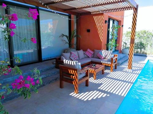 a patio with a couch and chairs next to a pool at Luxury Villa With a Pool in Soma Bay in Hurghada