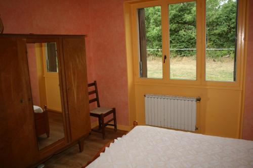 - une chambre avec un lit, une fenêtre et une chaise dans l'établissement HAVRE DE PAIX A LOUBEYRAT EN AUVERGNE, à Loubeyrat