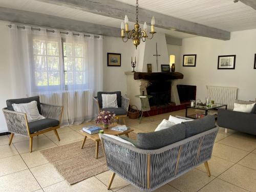 - un salon avec un canapé, des chaises et une cheminée dans l'établissement Mas du Grand Pin - Villa sur grande pinède, Site naturel exceptionnel, Calanque du Port d'Alon à 2pas, à Saint-Cyr-sur-Mer