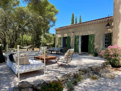 un patio avec des chaises et une table devant une maison dans l'établissement Mas du Grand Pin - Villa sur grande pinède, Site naturel exceptionnel, Calanque du Port d'Alon à 2pas, à Saint-Cyr-sur-Mer