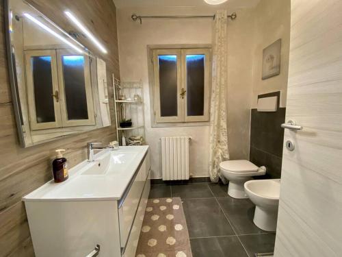 uma casa de banho branca com um lavatório e um WC em Trilocale Sul Lungomare em Cannigione