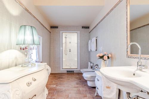 een badkamer met 2 wastafels, een toilet en een spiegel bij Villa Cedri in Montecatini Val di Cecina