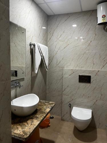 uma casa de banho com um lavatório e um WC em Roomquet comfort inn em Allahabad