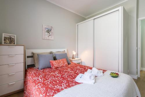 a bedroom with a large bed with a red bedspread at Host Wise - Modern Flats with Stunning Terrace or Balcony - Central Location in Porto