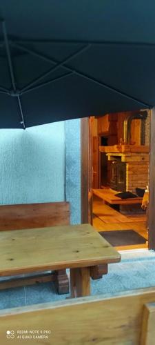 a wooden table and bench in a room with a fireplace at Apartman Šipak in Fužine