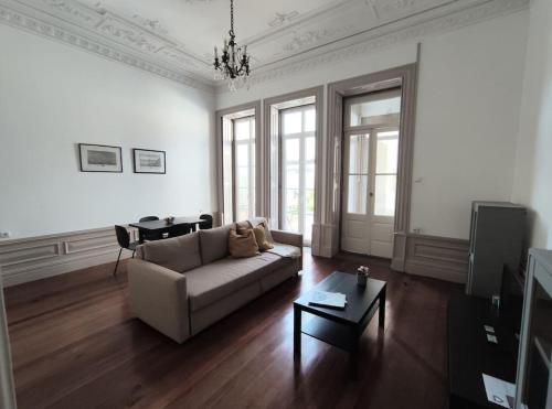 ein Wohnzimmer mit einem Sofa und einem Tisch in der Unterkunft Alvares Cabral Apartamento C in Porto
