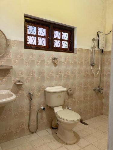 a bathroom with a toilet and a shower at Springvalley Holiday Home in Badulla