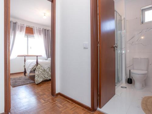 a bathroom with a toilet and a glass door at Figueira Casino Center Apartment in Figueira da Foz