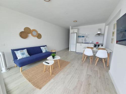 a living room with a blue couch and a table at Apartamento en Playa San Marcos in Icod de los Vinos
