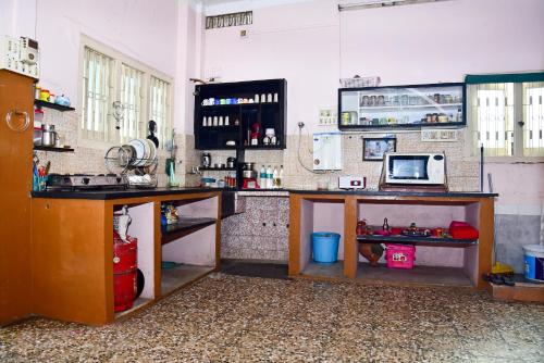 a kitchen with a table and a counter with a microwave at Perfect Homestay Ujjain in Ujjain