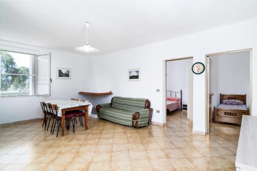 ein Wohnzimmer mit einem Tisch und einem Bett in der Unterkunft Casa con veranda in Posada
