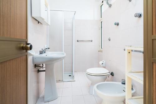 a white bathroom with a toilet and a sink at Casa con veranda in Posada