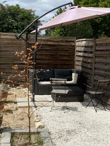 une terrasse avec un canapé, une table et un parasol dans l'établissement Chambre chaleureuse avec une vue dégagée, à La Frette-sur-Seine