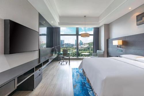 Cette chambre comprend un grand lit et une télévision à écran plat. dans l'établissement Renaissance Guiyang Hotel, à Guiyang