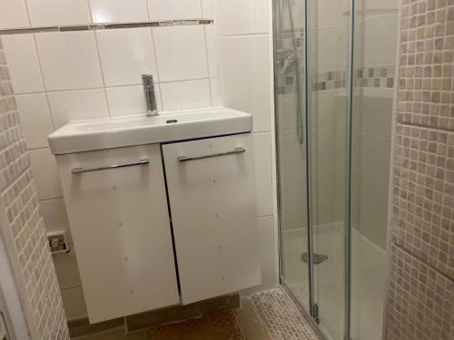 bagno bianco con lavandino e doccia di Belle montgeron a Montgeron
