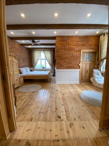 a large living room with wooden floors and a brick wall at Apartments PSD - Anny Łajming 2C in Słupsk