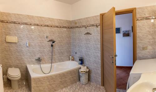 y baño con bañera, aseo y lavamanos. en Villa Elodie, en Torri