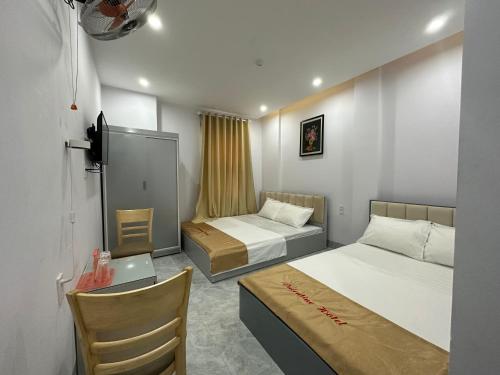 峴港的住宿－OYO 1190 Valentin Hotel，客房设有两张床、一张桌子和一张书桌。