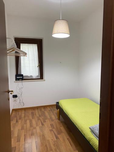 sypialnia z zielonym łóżkiem i oknem w obiekcie La Casetta in Collina 2 w mieście Spoltore