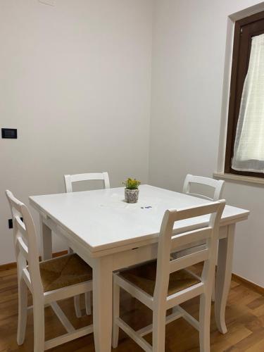 biały stół i krzesła z doniczką w obiekcie La Casetta in Collina 2 w mieście Spoltore