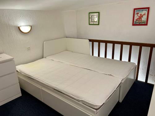 uma cama num pequeno quarto com um colchão branco em Studio avec piscine em La Garde-Freinet