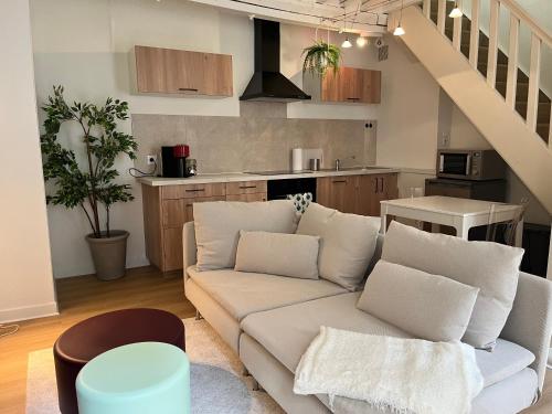 un salon avec un canapé et une cuisine dans l'établissement Duplex rénové au Calme et Central, à Caen