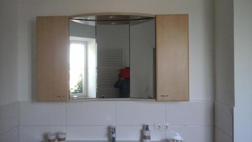 a mirror over a sink in a bathroom at Schloss Jetzendorf, Verwalterhaus in Jetzendorf