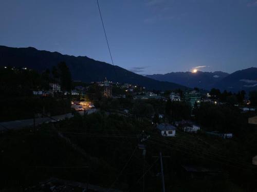 a view of a city at night with a mountain at Vamoose Sonam Guest House Tawang in Tawang