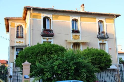 a yellow and white building with a tree in front of it at Villa Mon Rêve Apartements in Nice