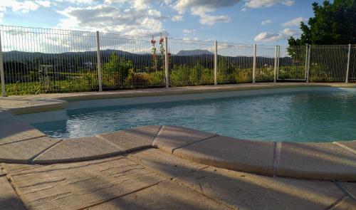 une piscine en face d'une clôture dans l'établissement Douceur Di'vignes - Appt avec piscine, à Rosières