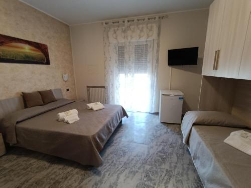 um quarto de hotel com duas camas e uma janela em B&B SOLE E MARE em Rossano