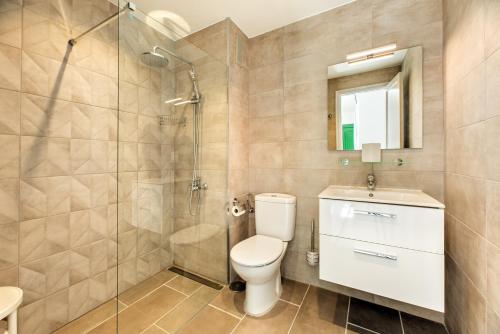 a bathroom with a shower and a toilet and a sink at Lanzahost Tuscan Atlantico in Costa Teguise