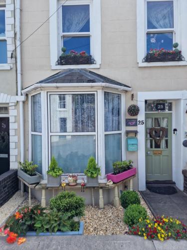 a house with windows and potted plants in front of it at Town Cottage ground floor appartment in Bridgend