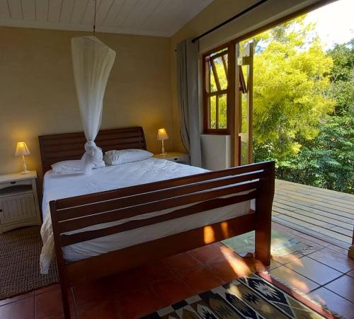 a bedroom with a bed and a large window at Willow's Rest in Barrydale
