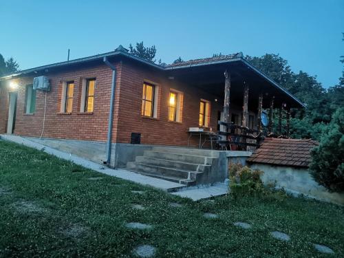 une petite maison en brique éclairée dans l'établissement Cottage House Official, à Niš