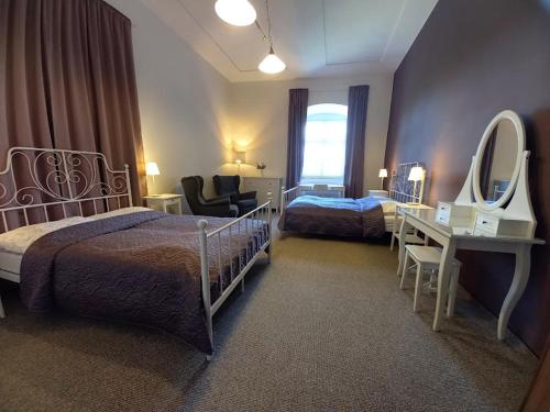 een hotelkamer met 2 bedden en een spiegel bij Penzion Zámek Rozsochatec in Rozsochatec