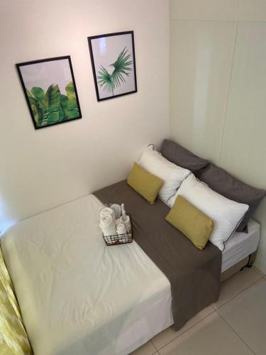 a bed in a room with two pillows on it at Unit 1005 Tower B Cool Suites at Wind Residences in Tagaytay