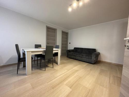 a dining room with a table and chairs and a couch at La casa di Giulia in Apricena