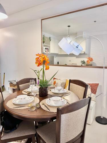 a dining room table and chairs with a table and a mirror at Scandinavian 1 BR beside SM CDO w POOL and Netflix in Cagayan de Oro