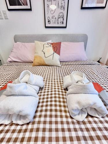 a bed with towels sitting on top of it at Scandinavian 1 BR beside SM CDO w POOL and Netflix in Cagayan de Oro