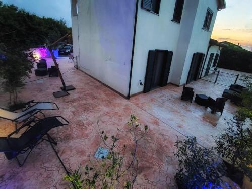 a patio with a white building and a table and chairs at Villetta di Anastasia 1 tropea in Filandari