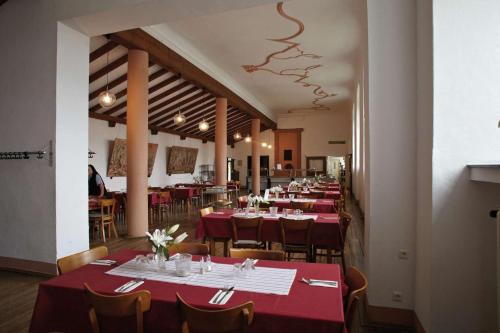 eine Reihe von Tischen in einem Restaurant mit rotem Tischtuch in der Unterkunft Kloster Steinfeld Gästehaus in Kall